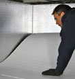 A contractor installing TerraBlock floor insulation in a De pere crawl space