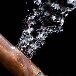 A bursting copper pipe in Sheboygan, with water gushing out.