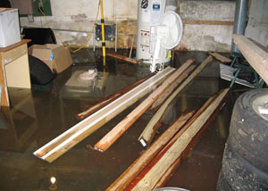 A severely flooding basement in Stevens Point, with lumber and personal items floating in a foot of water
