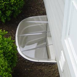 A vinyl basement window and covered window well in Plymouth