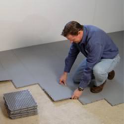 basement sub floor tiles being installed by a contractor in Schofield