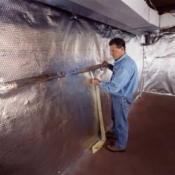 Installation of a radiant heat and vapor barrier on a basement wall in Waupaca