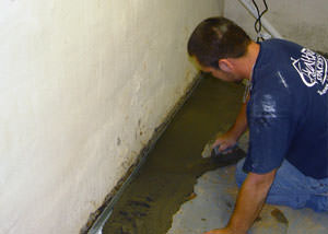 Restoring a concrete slab floor with fresh concrete after jackhammering it and installing a drain system in Schofield.