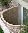 A durable plastic egress window well installed in a rock garden in Neenah.