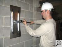 Attempting to straighten a bowed foundation wall by straightening a wall anchor system in a Stevens Point home.