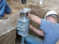 Foundation repair contractors installing the foundation bracket in Oshkosh.