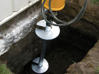 Installing a helical pier system in the earth around a foundation in Sheboygan